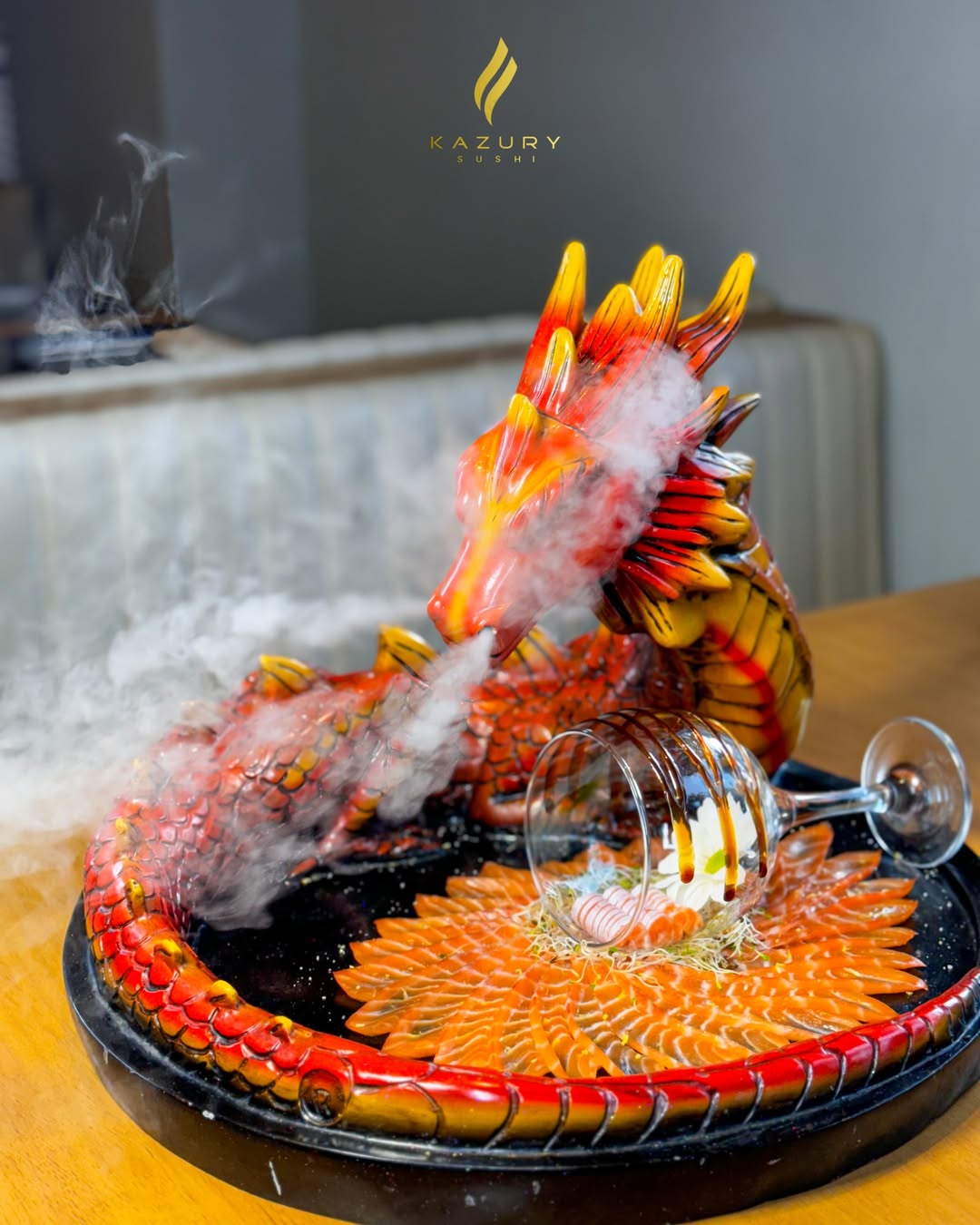 Prato assinatura Kazury Sushi servido com efeito de fumaça sobre escultura de dragão